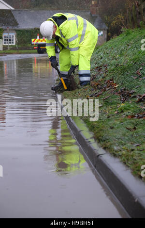 Combe, Herefordshire, UK. 21 Novembre, 2016. Un lavoratore di Herefordshire County Council tenta di cancellare bloccati scarichi stradali sotto l allagamento presso la frazione di Combe tra Shobdon e Presteigne ( Galles ) proprio sul confine di Inghilterra e Galles dopo una notte e la mattina della persistente pioggia pesante. Foto Stock