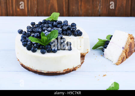 Mirtillo cheesecake su un bianco sullo sfondo di legno Foto Stock