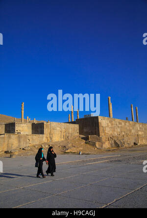 Due donne iraniane che passa di fronte al sito di Persepolis, far provincia, Marvdasht, Iran Foto Stock