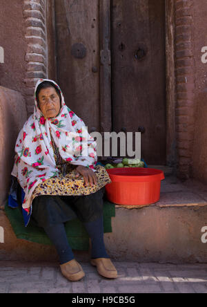 Ritratto di una donna iraniana indossando il tradizionale floreal chador la cottura di mele, Natanz county, Abyaneh, Iran Foto Stock