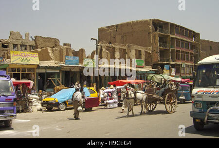 Il 29 maggio 2004 una tipica scena di strada a Kabul, Afghanistan: la vita va avanti per bomba-gli edifici danneggiati. Foto Stock