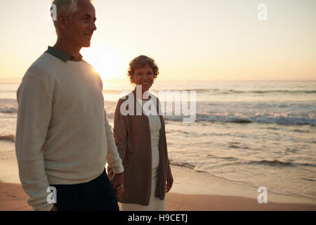 Senior donna con suo marito per passeggiare sulla spiaggia. Coppia matura camminare insieme dal mare. Foto Stock