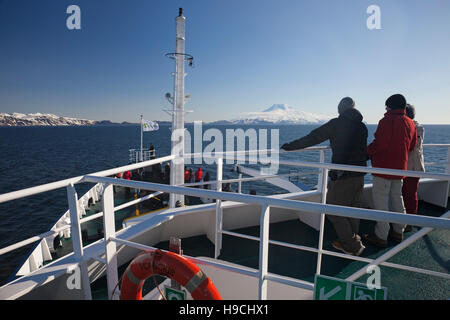 Eco-turisti a bordo della Expedition nave m/v Plancius guardando coperta di neve Beerenberg vulcano sull isola di Jan Mayen in primavera Foto Stock