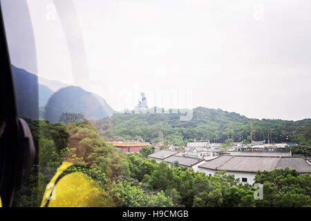 Vista del Big Buddha sull'Isola di Lantau dalla gondola con la riflessione del passeggero Foto Stock