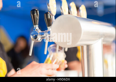 Barman mano alla birra tocca una colata di siccità birra chiara con sede di servizio in un ristorante o pub. Foto Stock