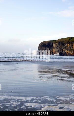 Lone surfer Surf le onde invernali a ballybunion spiaggia sul selvaggio modo atlantico Foto Stock