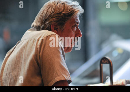Capelli grigi l uomo da solo in un ristorante Foto Stock