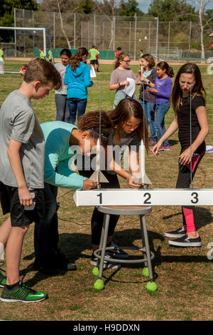 Multirazziale Mission Viejo, CA, middle school gli studenti a prepararsi per il lancio di una polvere nera di razzi come parte del loro programma di studi scientifici. Nota numerata rotaie di lancio. Foto Stock