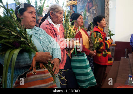 La Valle Sacra, Pisac, Perù. All interno della chiesa. La montagna persone che indossano costumi tradizionali nella chiesa di Pisac domenica giorno di mercato. Pisac. Sacre Foto Stock