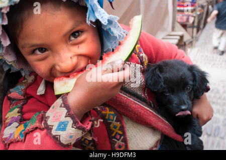 La Valle Sacra, Pisac, Perù. Una ragazza vestita di un costume tradizionale di mangiare un pezzo di anguria in Pisac domenica giorno di mercato. Pisac. La Valle Sacra. Pis Foto Stock