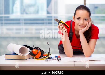 Giovane donna in tute le riparazioni facendo Foto Stock