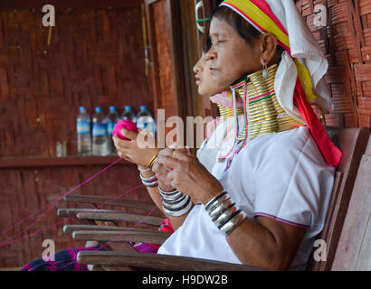 Padaung 'lungo collo donna", indossando i tradizionali anelli di metallo intorno al suo collo, tessitura su un telaio Foto Stock