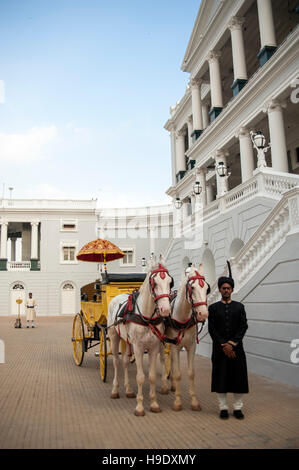 Un allenatore di antiquariato e albino cavalli fuori Falaknuma Palace a Hyderabad, in India. Foto Stock