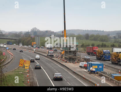 Costruzione di un nuovo ponte per la A46 che copre l'autostrada M40, Oxfordshire, Regno Unito. Casseforme per pontili e gru all'interno della riserva centrale. Foto Stock