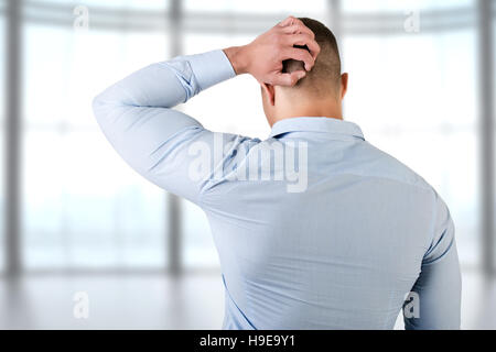 L'uomo holding è a capo di frustrazione, isolato in bianco Foto Stock