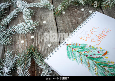 Composizione di natale. Rami di abete rosso, candy cane, il simbolo del fiocco di neve per bambini, lettere di Santa, cannella, anice stellato su uno sfondo di legno. Foto Stock