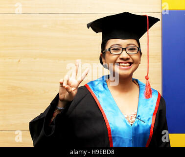 Donne asiatiche in una suite di graduazione sorridendo dopo è stato graduato. Foto Stock