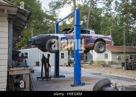 Bistrattato race car seduti su un ponte nel retro di un garage. Foto Stock