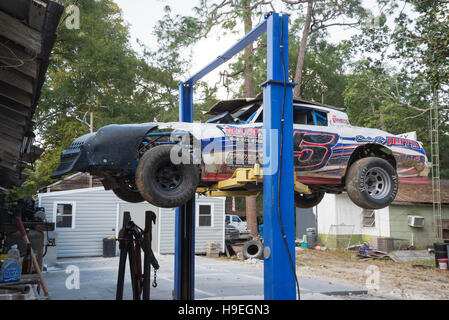 Bistrattato race car seduti su un ponte nel retro di un garage. Foto Stock