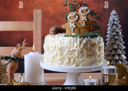 Festa di Natale vacanze impediva di procedere centrotavola bianco torta al cioccolato con pan di zenzero uomini cooklies e il rosmarino e decorazioni di alberi in un moderno rusti Foto Stock