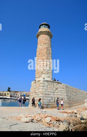 Vista del faro nel porto con i turisti a piedi lungo il seawall, Rethimno, Creta, Grecia, l'Europa. Foto Stock