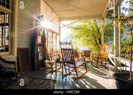 La riflessione del sole sulla veranda con sedie a dondolo Foto Stock