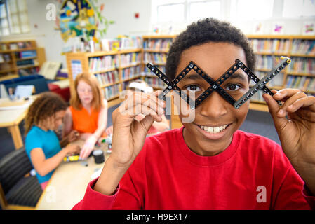 Ragazzo giocando con dei blocchi di materia plastica in libreria Foto Stock