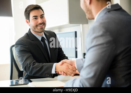 Uomini d'affari si stringono la mano in ufficio Foto Stock