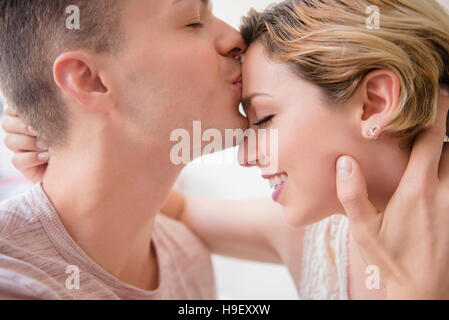 Uomo caucasico kissing ragazza sul fronte Foto Stock