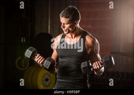 Uomo caucasico il sollevamento pesi in palestra Foto Stock