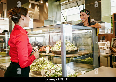 Lavoratore assistere imprenditrice nel food court Foto Stock