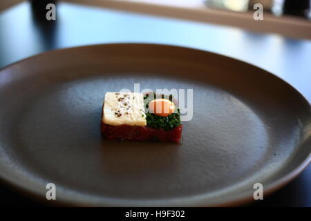 Tartare di cervo con quaglie tuorlo d'uovo, il burro ed erba cipollina Foto Stock