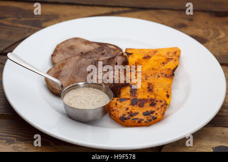 Linguetta di carne con la salsa e zucca Foto Stock