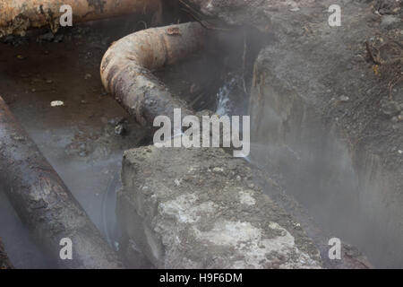 Rotture di vecchie tubazioni del sistema di riscaldamento; di spruzzi di acqua sotto pressione Foto Stock