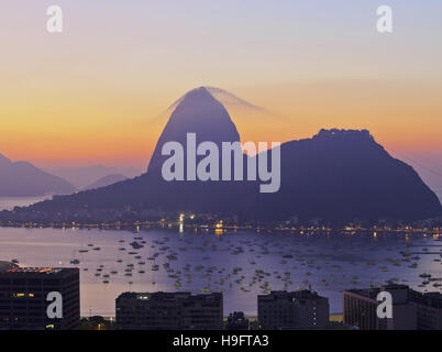 Il Brasile, la città di Rio de Janeiro, vista sul quartiere di Botafogo verso la montagna di Sugarloaf a sunrise. Foto Stock