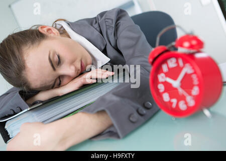 Donna che Dorme sul tavolo durante il lavoro Foto Stock