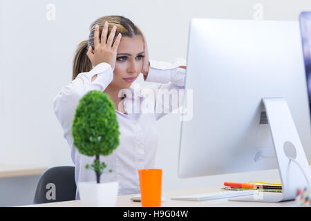 Ritratto di donna seduta imprenditore in ufficio mentre doin Foto Stock