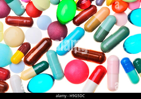 Molte pillole colorate isolato su bianco Foto Stock