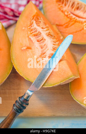 Melone fette di melone e il coltello, il fuoco selettivo Foto Stock