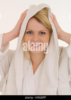 Giovane donna in una vasca da bagno Accappatoio in spugna i suoi capelli Foto Stock