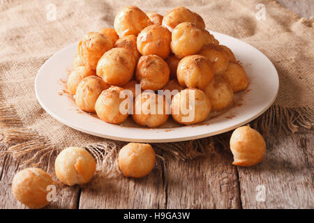 Piccole ciambelle con miele e cannella vicino sul tavolo orizzontale. Foto Stock