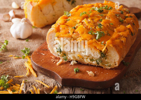 Pane con formaggio cheddar, aglio ed erbe aromatiche closeup sul tavolo orizzontale. Foto Stock