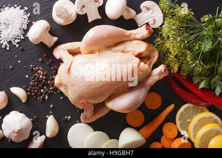 Il pollo crudo con ingredienti per il brodo di cottura vicino sul tavolo. vista orizzontale dal di sopra Foto Stock