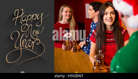 Immagine composita di amici avente birre durante il periodo di Natale Foto Stock