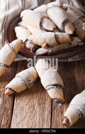 Crescent rotoli con ripieno di papavero close-up su una piastra sul piano verticale. Foto Stock