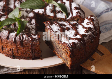 Gustosa torta con semi di papavero e zucchero a velo e menta vicino sul tavolo orizzontale. Foto Stock