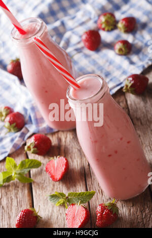 Freddo frullato fragole con la menta in bottiglie di vetro vicino sul piano verticale. Foto Stock