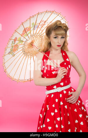 Pin up girl con ombrellone indossando indumenti vintatge Foto Stock