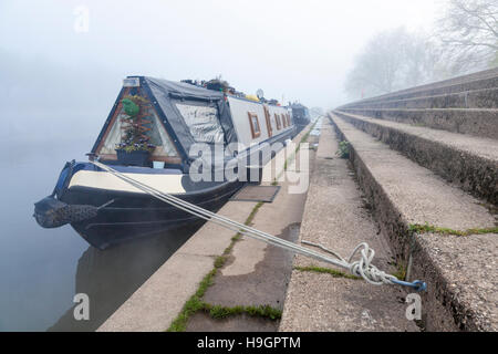 Nebbia di fiume. Narrowboat ormeggiata sulla riva del fiume Trent in una nebbiosa giornata, West Bridgford, Nottinghamshire, England, Regno Unito Foto Stock