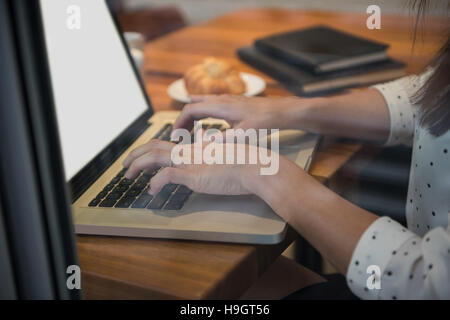 Imprenditrice utilizzando laptop in cafÃ© Foto Stock